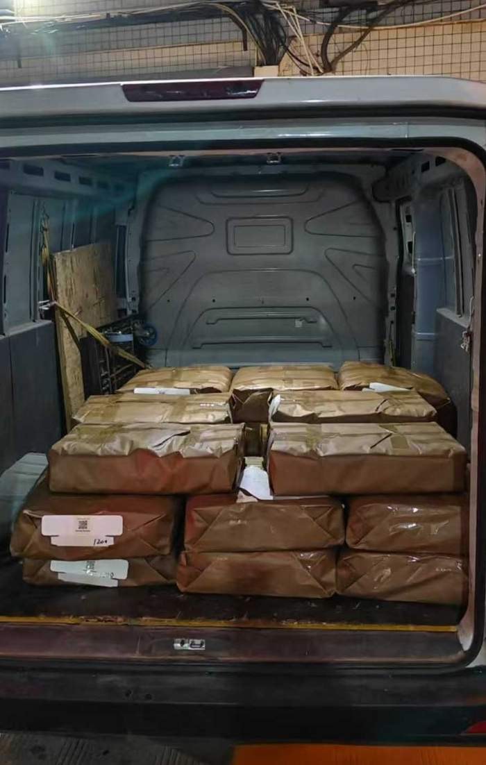 Boxes of JetKVM manuals being shipped to the assembly facility.